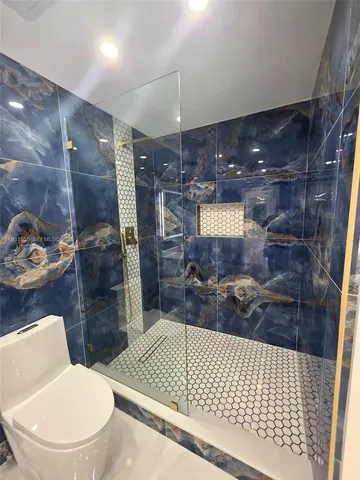 a bathroom with a toilet and a shower