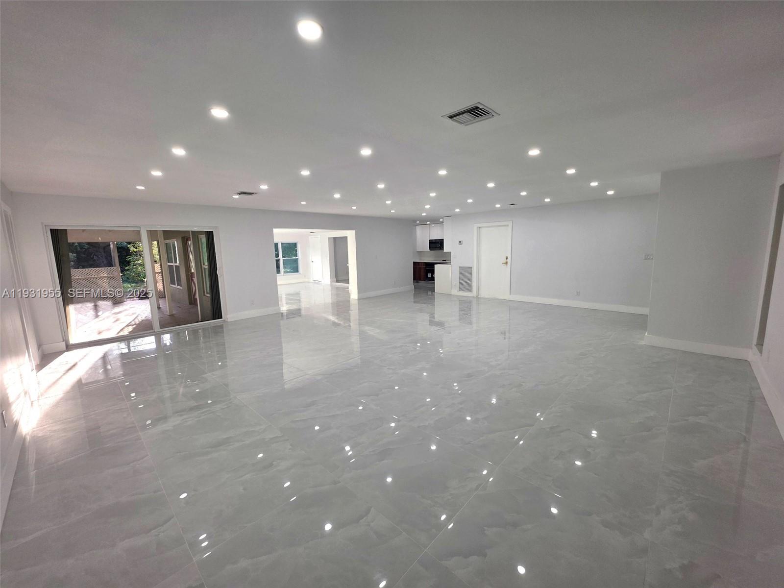 Davie Davie, FL 33314 - Photo 8 of 44 a view of an empty room with wooden floor and kitchen