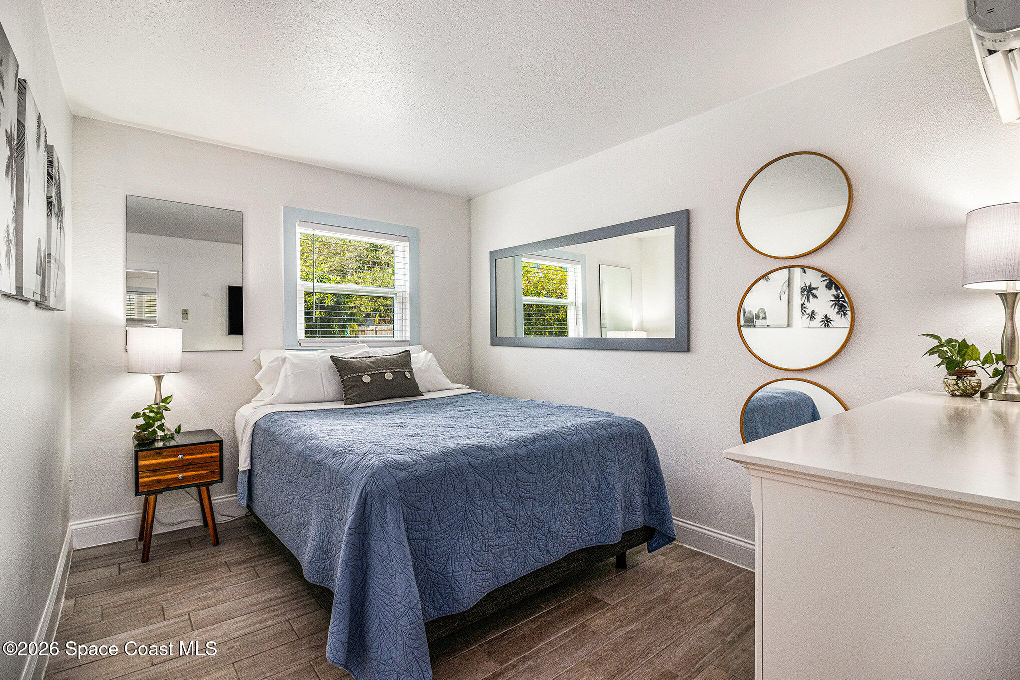 7605 Ridgewood Avenue, Unit 3 Cape Canaveral, FL 32920 - Photo 13 of 28 a bedroom with bed and a chandelier