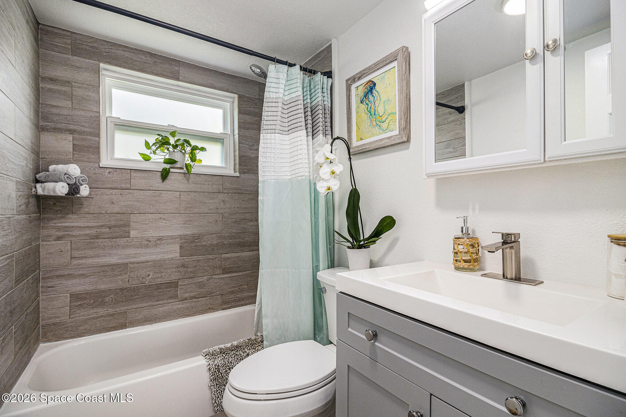 7605 Ridgewood Avenue, Unit 3 Cape Canaveral, FL 32920 - Photo 14 of 28 a bathroom with a sink a toilet and shower
