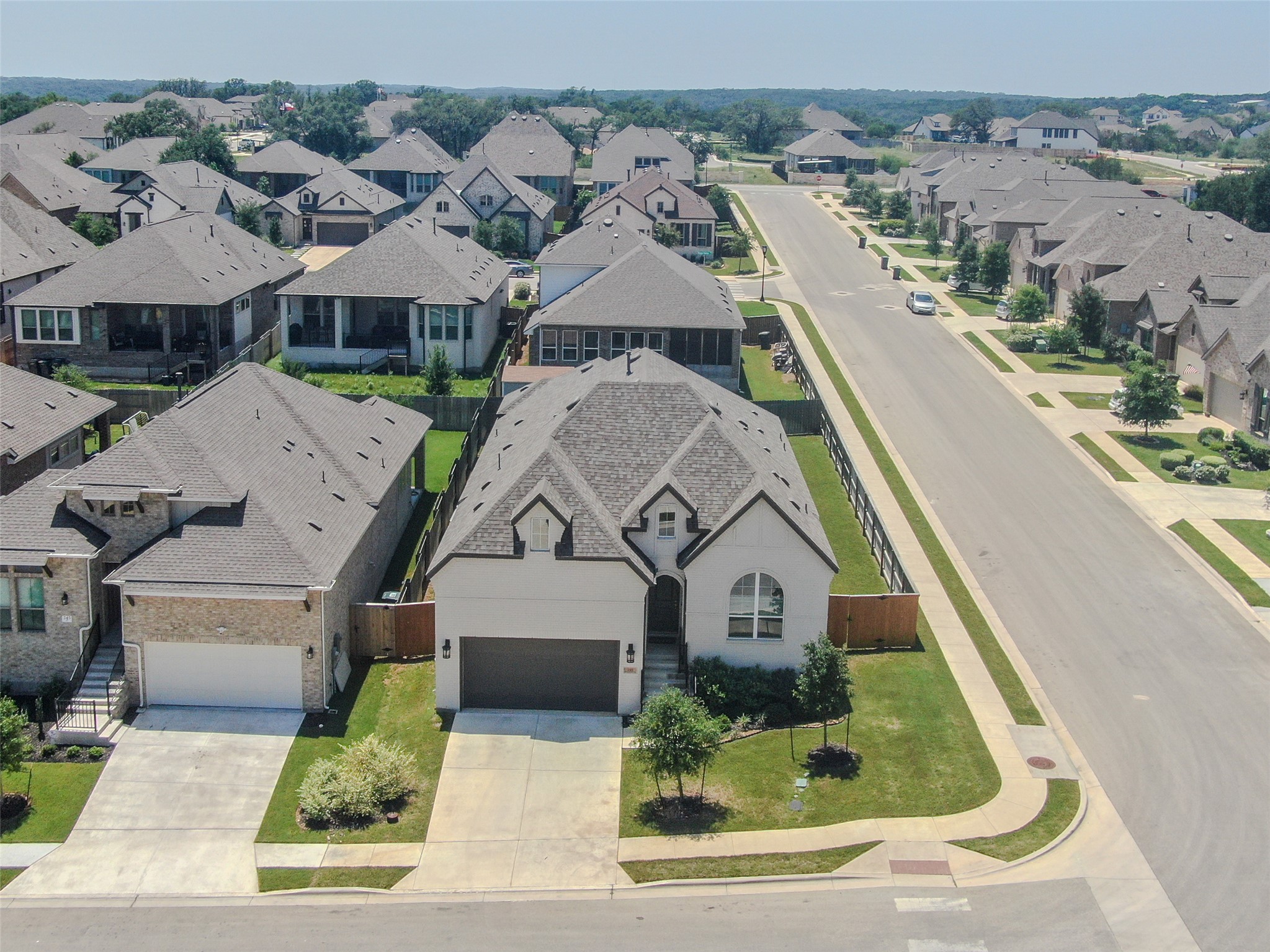 An aerial perspective reveals a charming residential community, featuring a mix of modern homes with well-kept lawns.