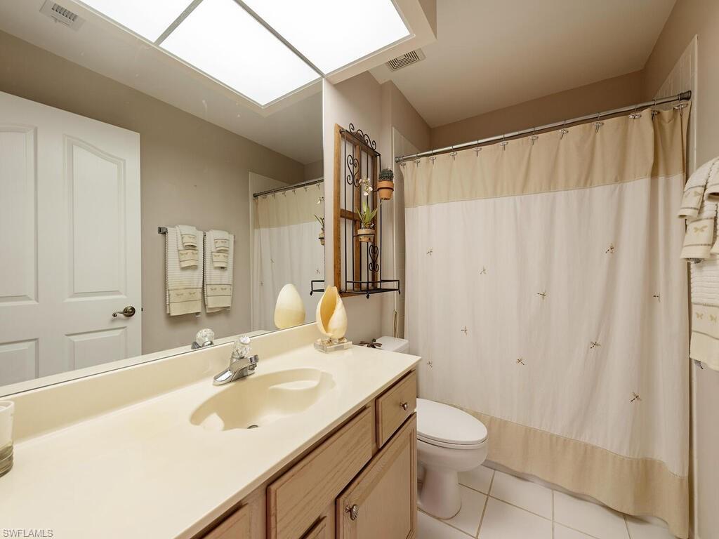 3572 Windjammer Circle, Unit 1404 Naples, FL 34112 - Photo 11 of 17 a bathroom with a sink toilet and shower