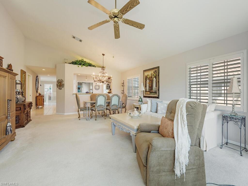 3572 Windjammer Circle, Unit 1404 Naples, FL 34112 - Photo 2 of 17 a living room with furniture and a large window
