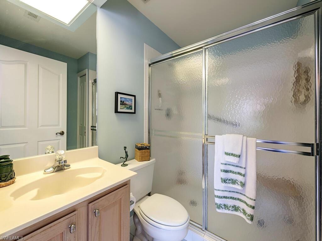 3572 Windjammer Circle, Unit 1404 Naples, FL 34112 - Photo 9 of 17 a bathroom with a sink a toilet and shower
