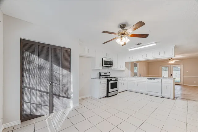 a kitchen with granite countertop a refrigerator and a stove top oven