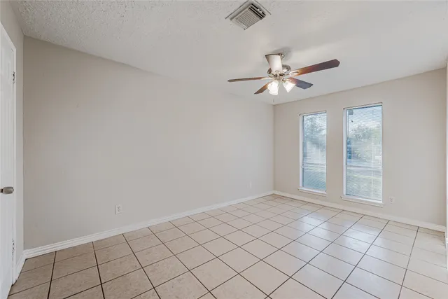 a view of an empty room and chandelier fan