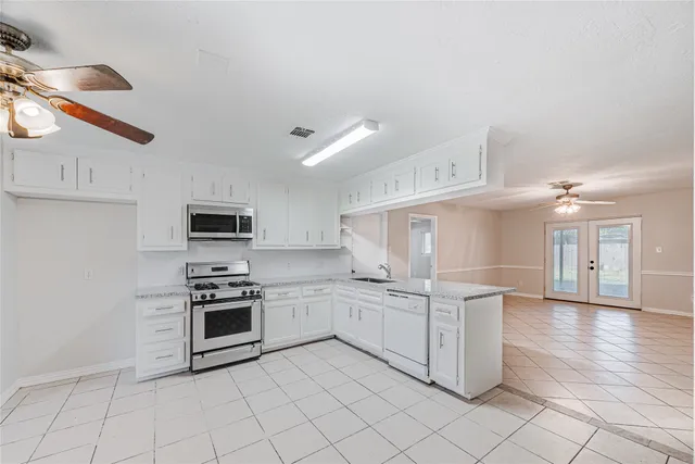 a kitchen with white cabinets a sink and appliances