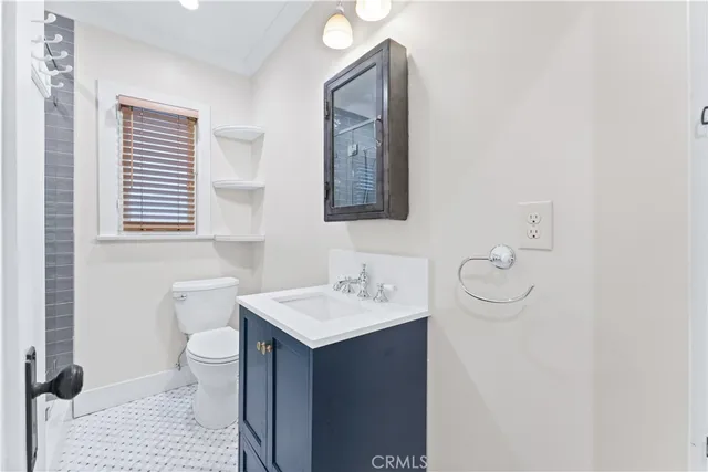 a bathroom with a toilet sink vanity and mirror