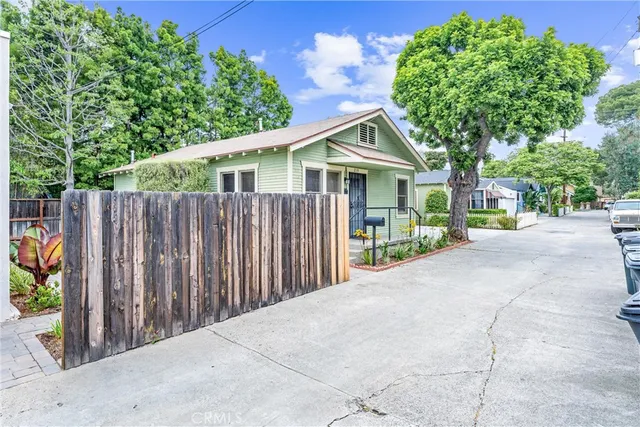 a view of a house with wooden fence next to a road