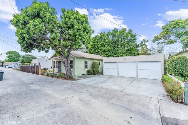 a view of a house with a tree and plants