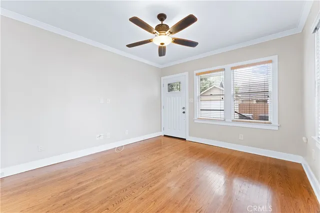 an empty room with window and ceiling fan