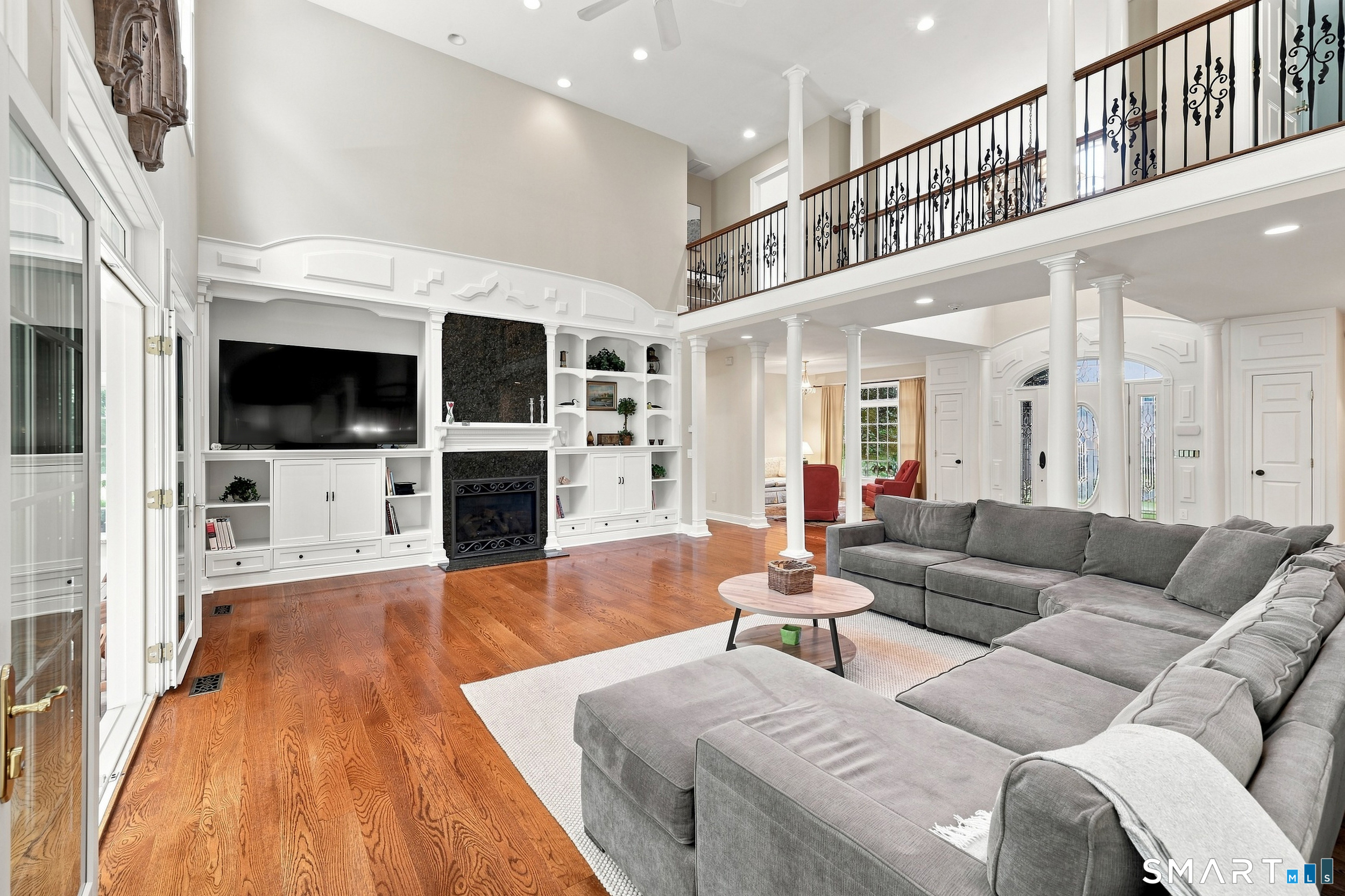 122 Lower Road Guilford, CT 06437 - Photo 8 of 39 A gas fireplace serves as a warm focal point, while French doors open to a year-round sun porch, creating a seamless indoor-outdoor connection ideal for relaxing and entertaining.