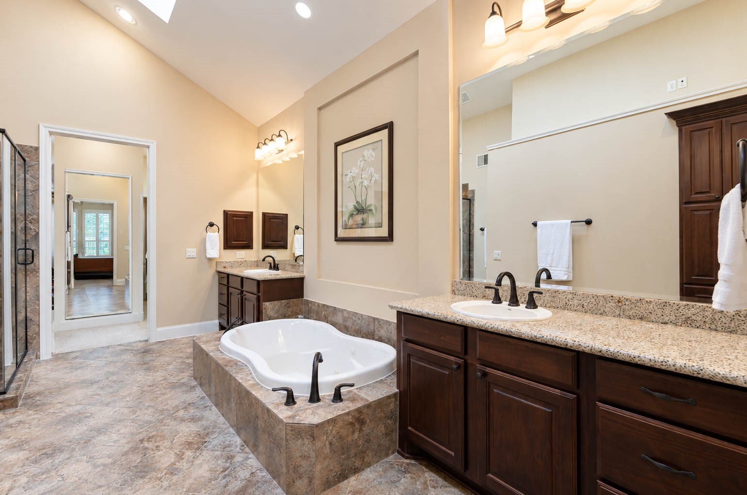 91 Lake View Loop Fulshear, TX 77441 - Photo 5 of 42 This spa-like ensuite bathroom offers dual vanities each with its own sink, a relaxing soaking tub, and a separate walk-in shower. Soaring ceilings and generous space create a truly grand and rejuvenating retreat.