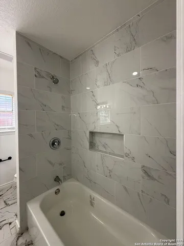 a bathroom with a bathtub and a shower