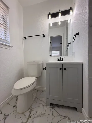 a bathroom with a toilet sink and mirror
