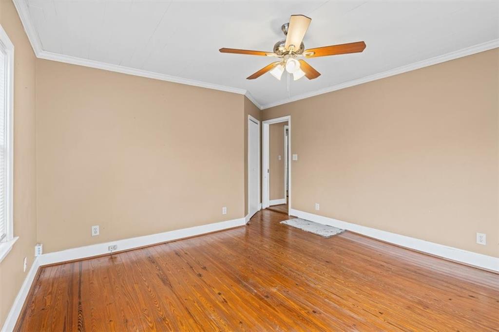 202 Gordon Street Rockmart, GA 30153 - Photo 13 of 25 an empty room with wooden floor and ceiling fan