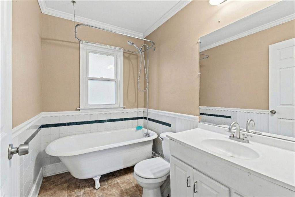 202 Gordon Street Rockmart, GA 30153 - Photo 15 of 25 a bathroom with a granite countertop toilet a sink and a bathtub