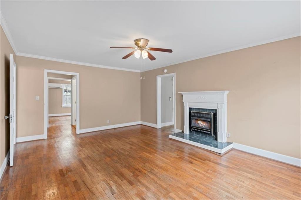 202 Gordon Street Rockmart, GA 30153 - Photo 6 of 25 a view of an empty room with wooden floor fireplace and a window