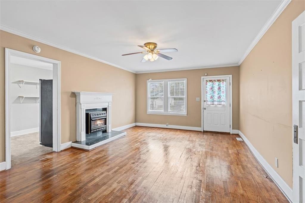 202 Gordon Street Rockmart, GA 30153 - Photo 8 of 25 an empty room with windows fireplace and a kitchen view