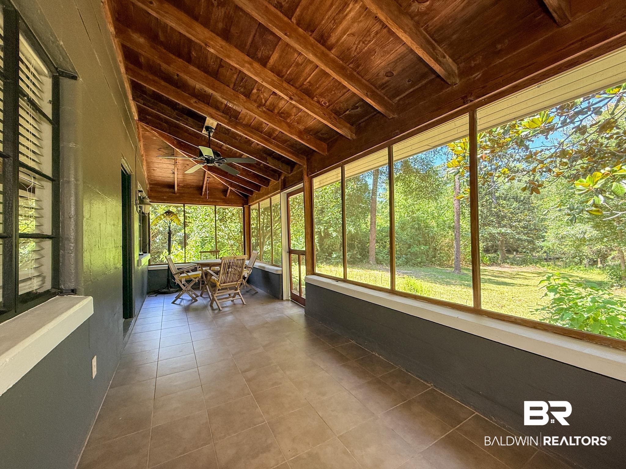 18711 Keller Road Foley, AL 36535 - Photo 27 of 38 Spacious screened porch featuring an exposed wood ceiling, tile flooring, and a ceiling fan