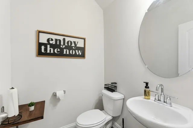 a bathroom with a toilet a sink and mirror