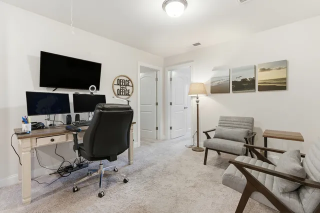 a view of a workspace with furniture and a flat screen tv