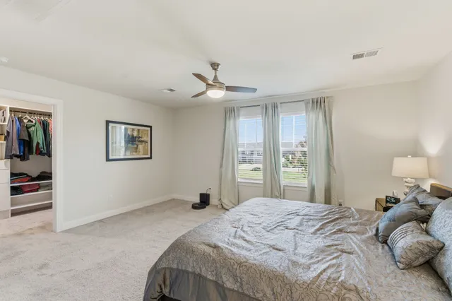 a bedroom with a large bed and a chandelier