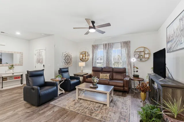 a living room with furniture a flat screen tv and a window