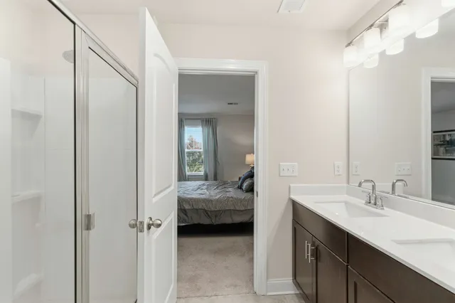 a en suite bathroom with a sink double vanity and shower