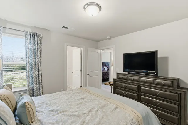a bedroom with a bed and a flat screen tv