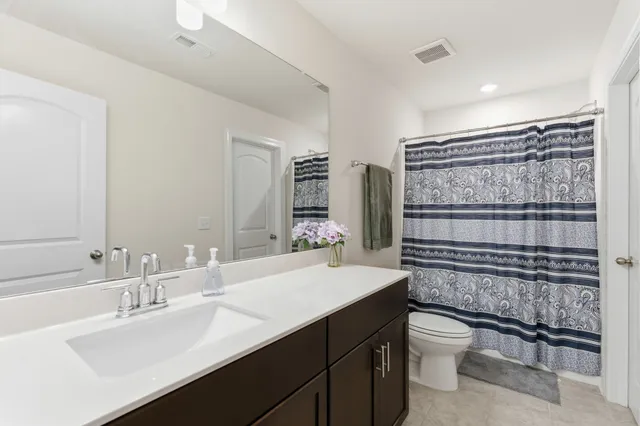 a bathroom with a sink toilet a mirror and shower