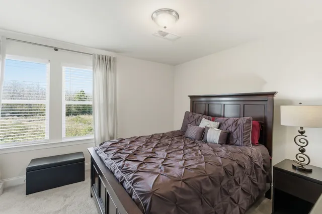 a bedroom with a large bed and a window