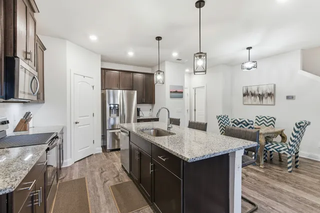 a kitchen with kitchen island a sink stove and refrigerator