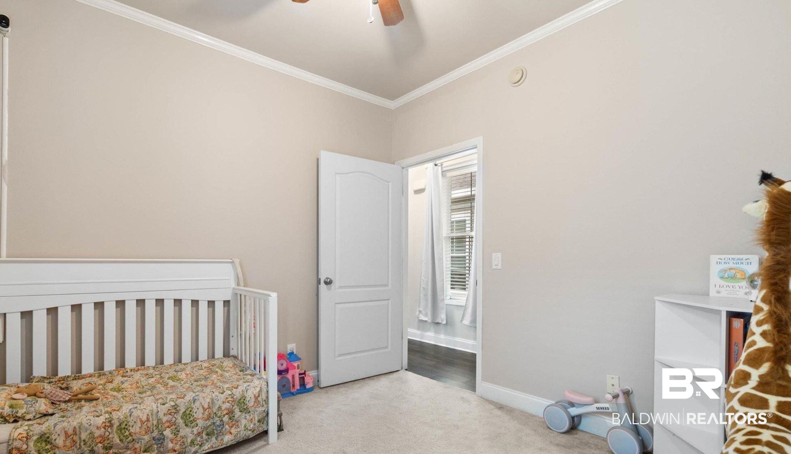 25806 Pollard Road, Unit 203 Daphne, AL 36526 - Photo 12 of 14 Bedroom featuring ornamental molding, carpet flooring, a nursery area, and a ceiling fan