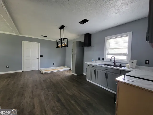 a kitchen with a sink cabinets and wooden floor
