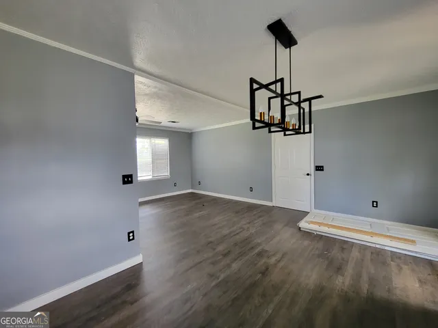 a view of a room with wooden floor and ceiling fan