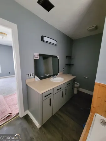 a bathroom with a toilet and a chair