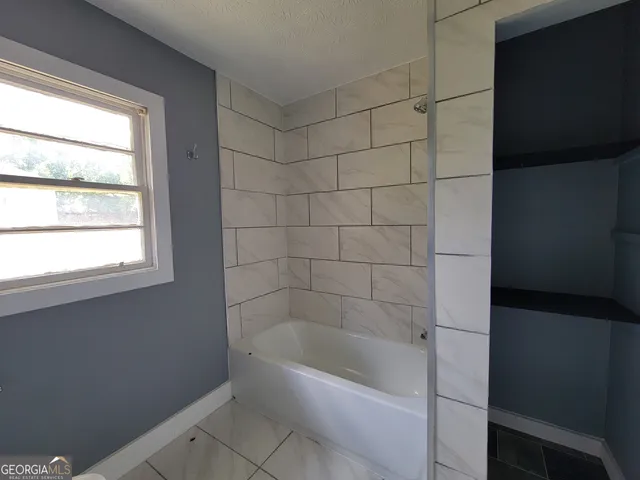 a bathroom with a bathtub and a shower
