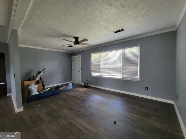 a view of room with hardwood floor and ceiling fan