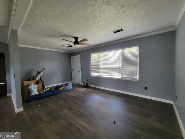 a view of room with hardwood floor and ceiling fan