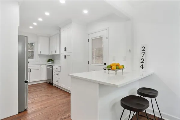 a kitchen with a sink a stove cabinets and wooden floor