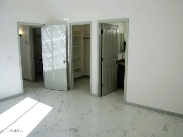 an empty room with closet and a bathroom