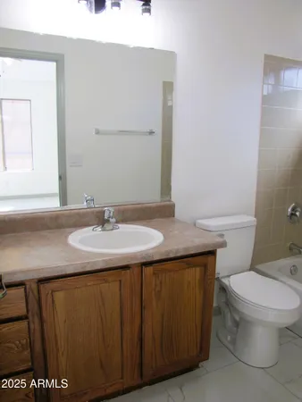 a bathroom with a granite countertop sink and a toilet