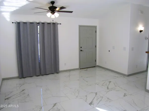 a view of a livingroom with a ceiling fan and carpet