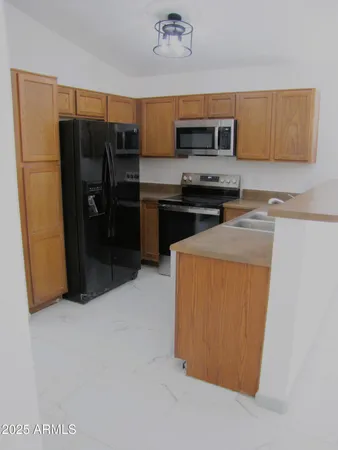 a kitchen with stainless steel appliances a refrigerator a stove a sink and a microwave