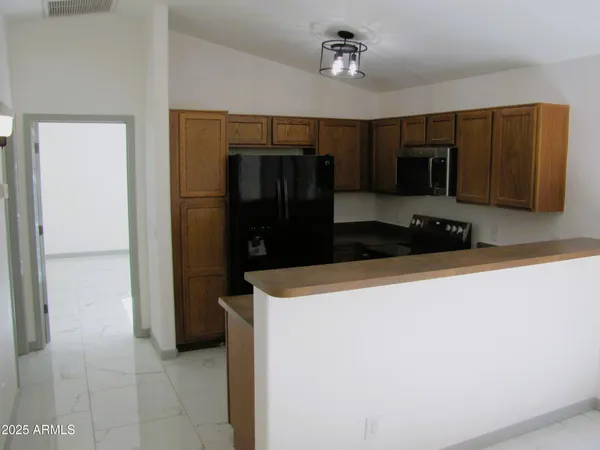a kitchen with a refrigerator and a stove top oven