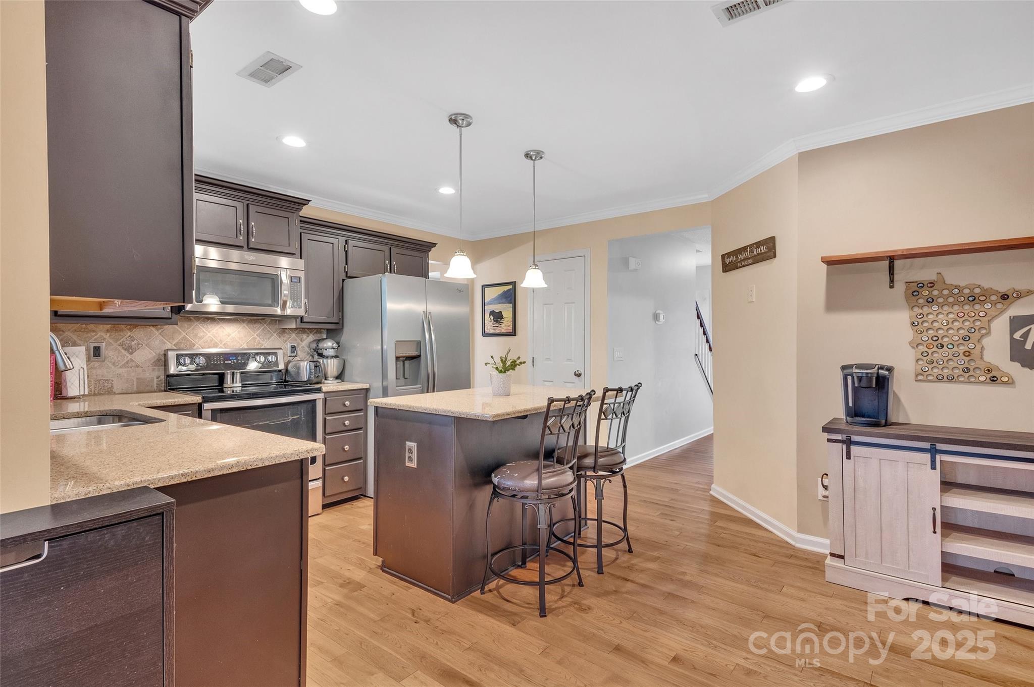 12351 Cardinal Point Road Charlotte, NC 28269 - Photo 15 of 43 a kitchen with stainless steel appliances granite countertop a refrigerator a stove a sink a dining table and chairs with wooden floor