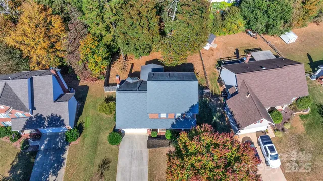 an aerial view of a house with a yard and trees