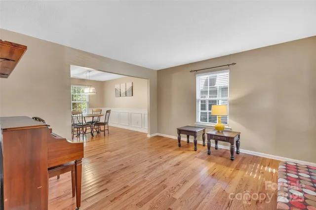 a living room with furniture a piano and wooden floor