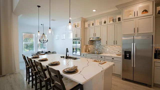 a kitchen with kitchen island a stove a table and chairs